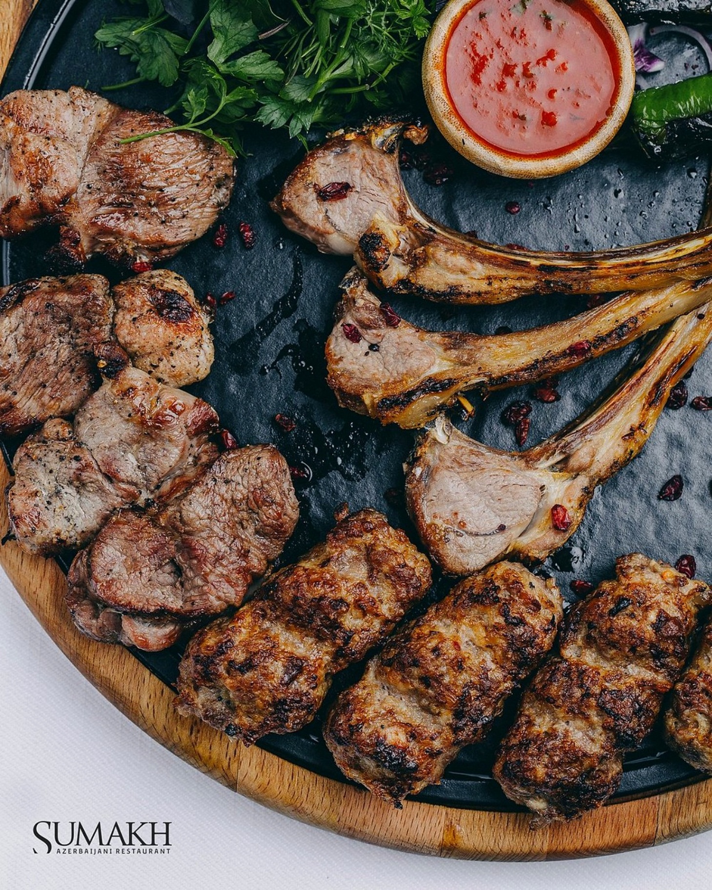 A platter of lamb chops, tenderloin and lülə kebab with herbs and tomato sauce at Sumakh in Baku