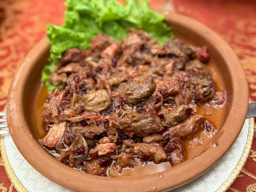Beef braised with onion and dried cherry, served in an earthenware bowl at Shirvanshah in Baku