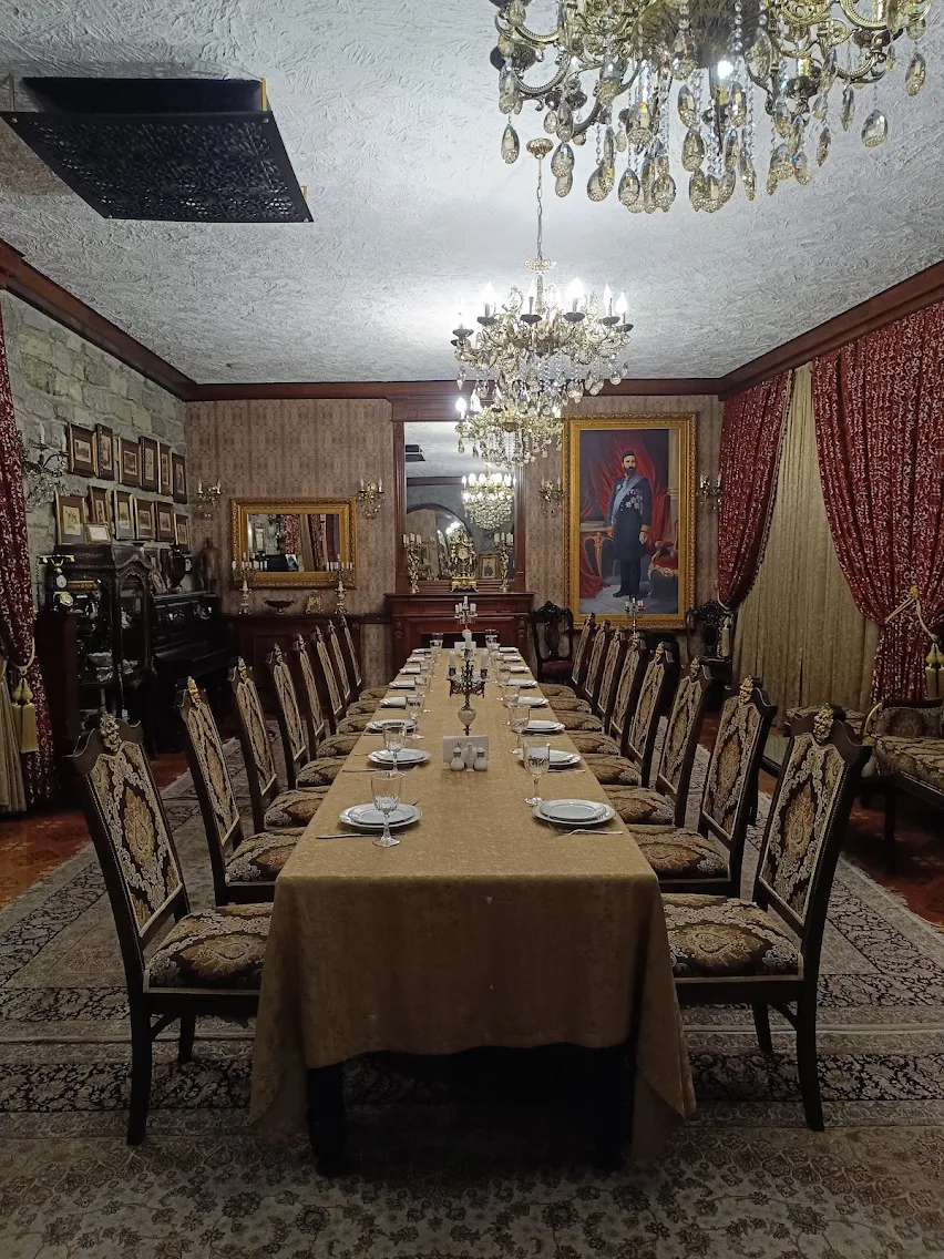 The private dining salon at Shirvanshah in Baku — long table, crystal chandeliers and antique portraiture