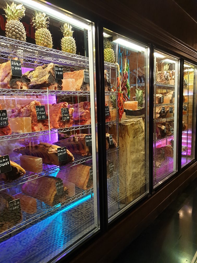 Glass dry-ageing cabinets lined with cuts of beef on Himalayan salt blocks at Mangal in Baku